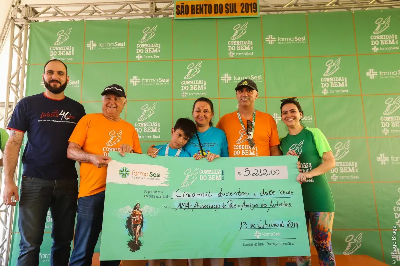Cheque simbólico foi entregue pelo vice-presidente regional da FIESC, Arnaldo Huebl, e pelo gerente do SESI e SENAI, Julcimar Machado. Foto: Thiago Braga